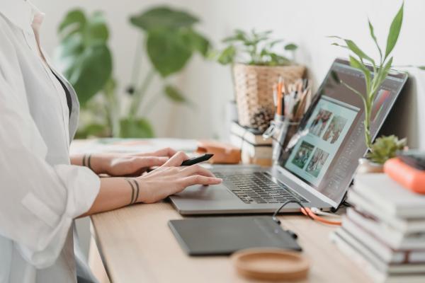 Frau sitzt an einem Schreibtisch mit Laptop