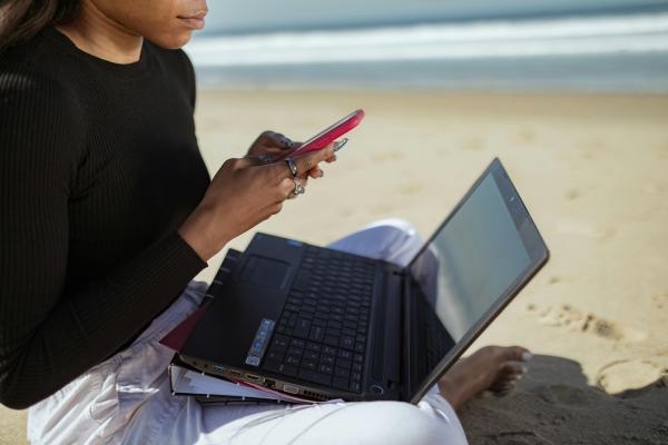 Frau mit Laptop am Strand